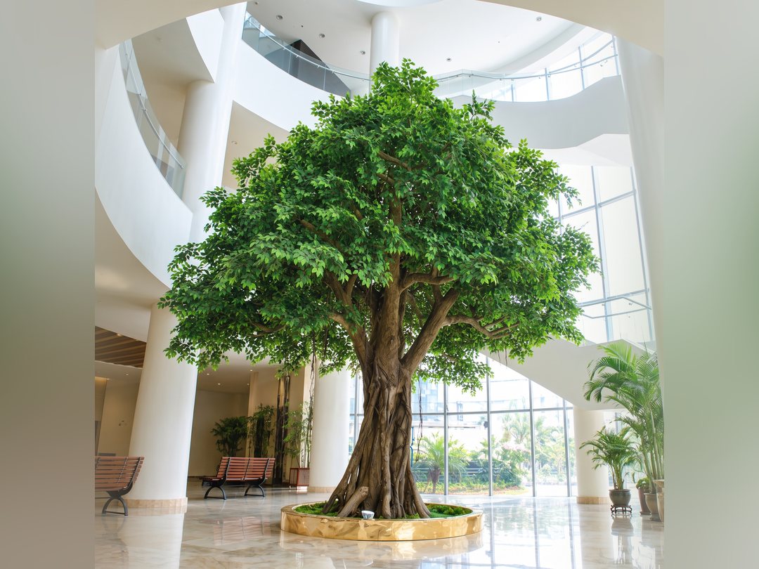 Completed artificial tree installed in a hotel atrium with dressed planter and polished floor