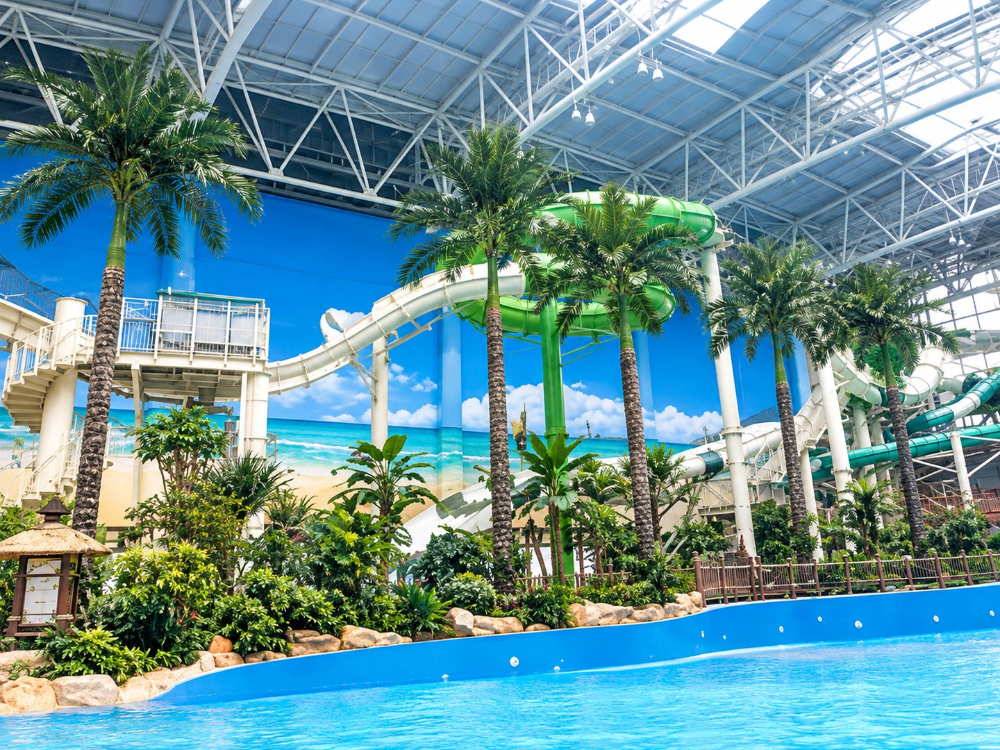 Artificial palms and tropical planting beside the water slides of an indoor water park